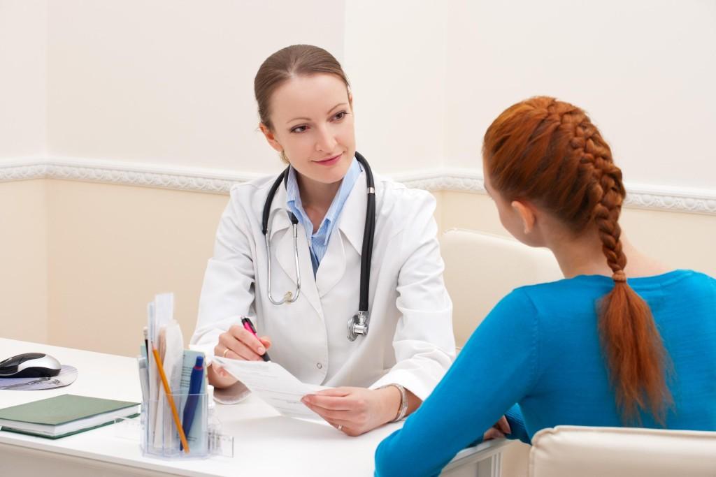 Doctor advises woman patient and showing prescription